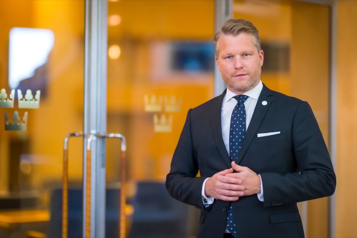 Alexander Christiansson i kostym i riksdagens lokaler.